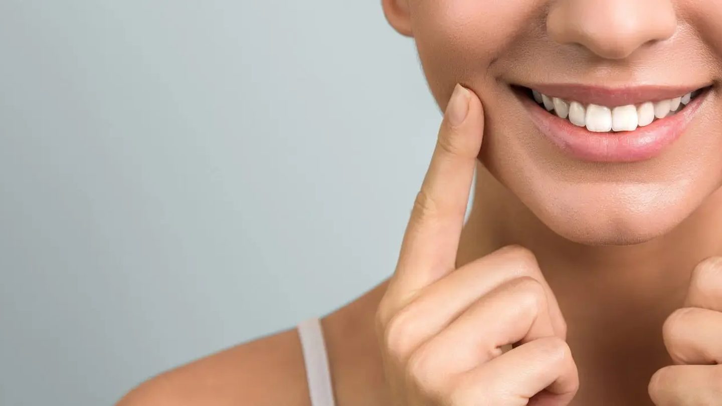 Woman pointing to her healthy smile
